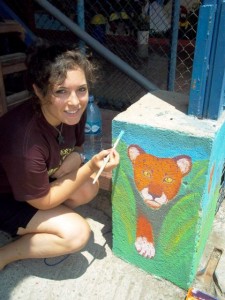 Paige Triola ’14 paints a mural at a local school. Paige Triola ’14 paints a mural at a local school.