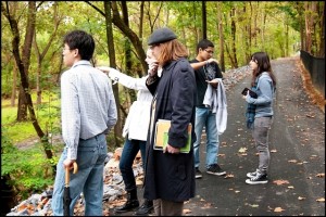 A student team scopes out possible locations for a miniature clay ziggurat sculpture along the Karl Stirner Arts Trail. The project was supported by the College's Mellon grant.