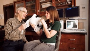 Robert Allan, associate professor of psychology, and Julia Brodsky ’13 interact with a bird in Allan’s lab.