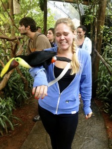Dolcie DeGrandchamp ’15 walks with a a toucan perched on her arm.