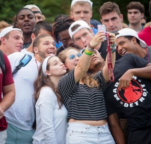 New students take a selfie before the class photo.