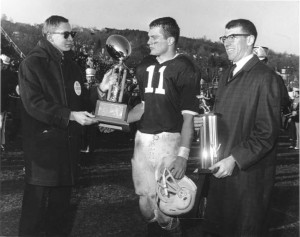 Lafayette quarterback George Hossenlopp ’65, center, receives the trophy for being named the outstanding player in the 100th Lafayette-Lehigh game in 1964 from John B. Hench ’65, president of the Lafayette Student Council. At right is Rodger Digilio, president of the Lehigh Student Council.