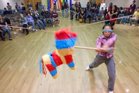 A student swings at the piñata.