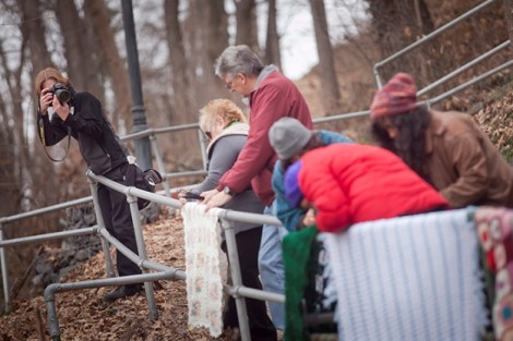 Volunteers attach afghans to the railing.