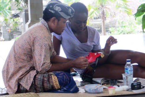 Oluwadamilare Oyefeso '15, right, gets some pointers during a mask painting class.