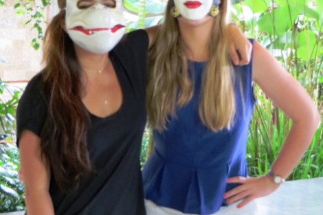 Two students show off the results of their traditional mask-making class.