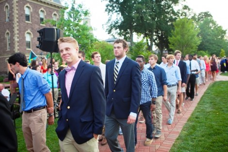 The student processional winds through the Quad.