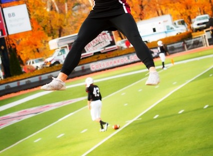 A cheerleader reaches for the sky.