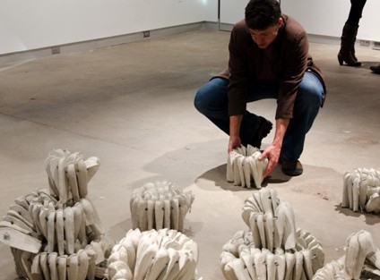 Nestor Gil adjusts his installation “Levantamiento.”