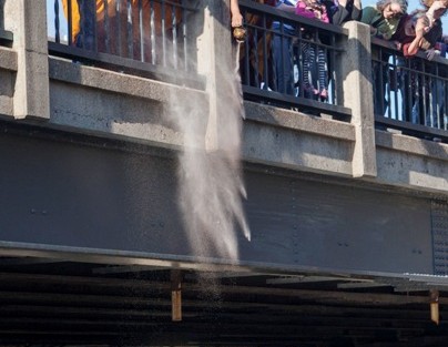 The monks place the remaining sand from the mandala in the Bushkill Creek.