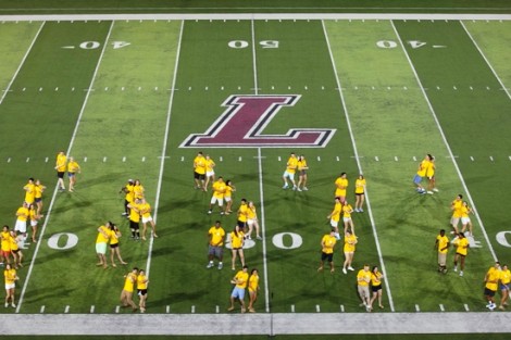 Orientation leaders perform on Fisher Field for the new students.