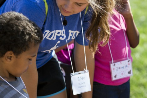 A camper shows Riley Godshall ’19 how he decorated his nametag.
