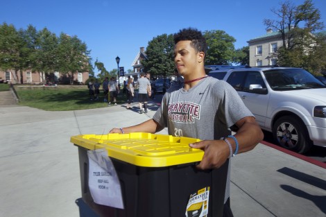 Football player Izaiah Avent ’19 carries another student’s items into Ruef Hall.