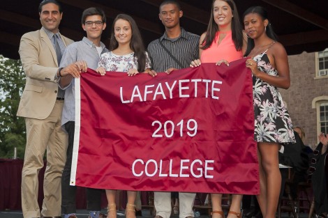 Alex Karapetian ’04, president of the Alumni Association, presents the students with the Class of 2019 banner.
