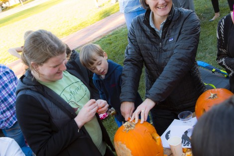 Haley Mauriello ’18 and Professor Kira Lawrence clean out a pumpkin with Lawrence’s son Kai.