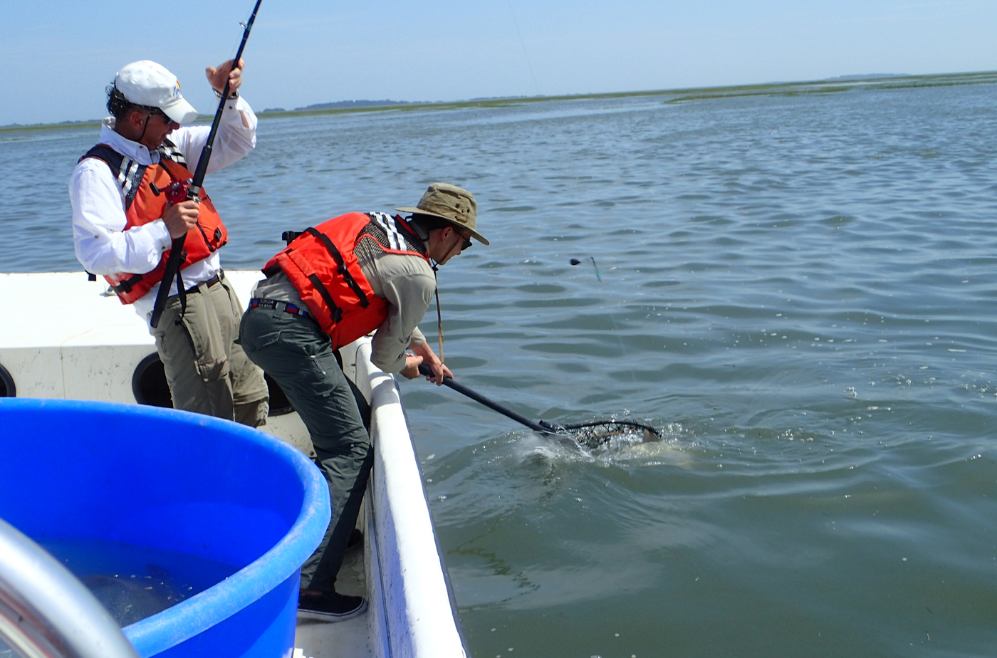 Richard Brill ’70 and Jacob Strock '17 work together to catch a fish.