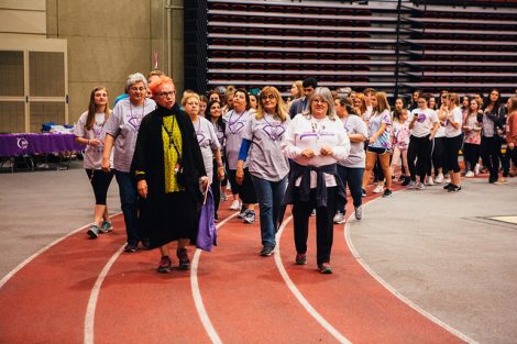 A crowd of mostly students walks around the indoor track at Relay for Life.