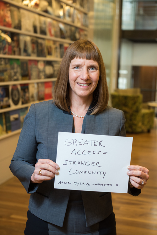 Lafayette President Alison Byerly holds a sign that reads "Greater Access = Stronger Community"