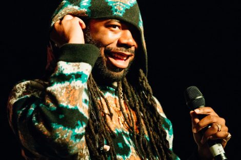 Rapper DRAM smiles while holding the microphone.