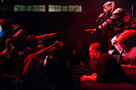 Lafayette College students reach their arms out to rapper DRAM as he performs on stage.