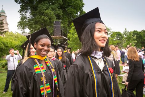 Two students smile as they walk at Commencement.