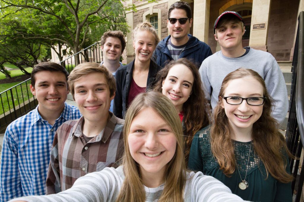 Nine students who received top awards pose for a photo outside.