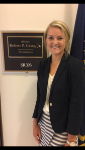 Haley Matthes '19 stands by the sign on the wall for Senator Bob Casey.
