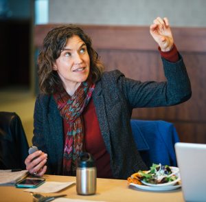 Marie Fechik-Kirk gives a presentation at a table