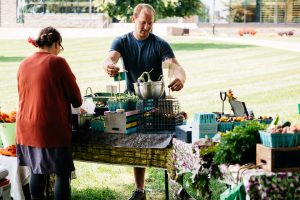 A student worker and the farm manager set up the LaFarm Marquis Market.