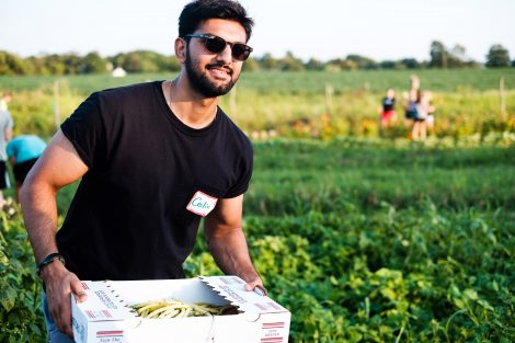 A student carries a basket of produce.