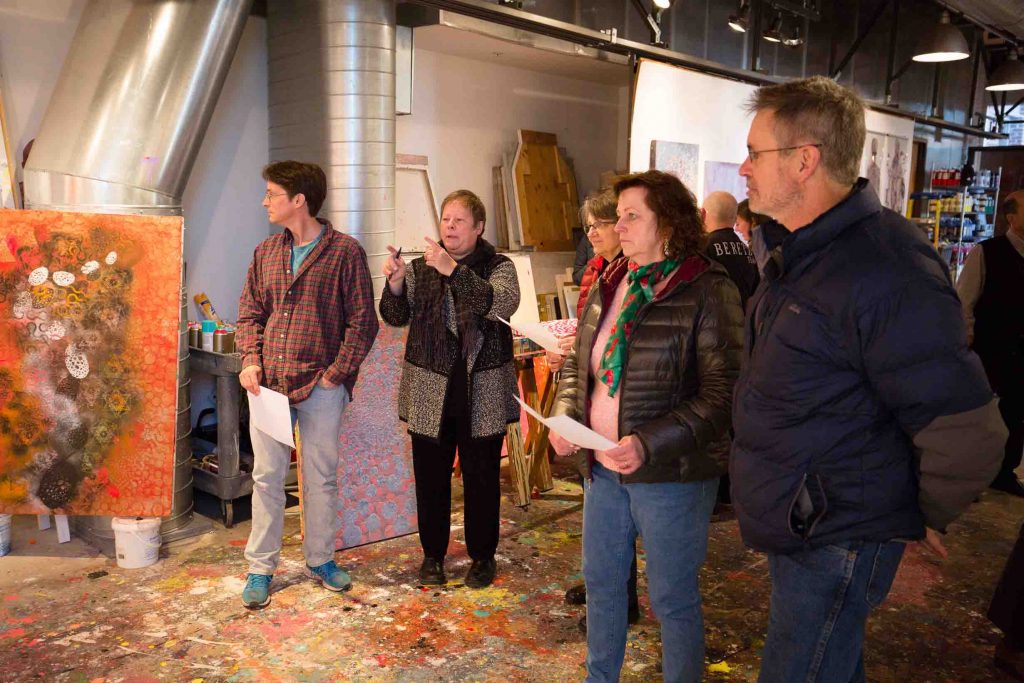 Biology faculty look at paintings in Ed Kerns' studio.