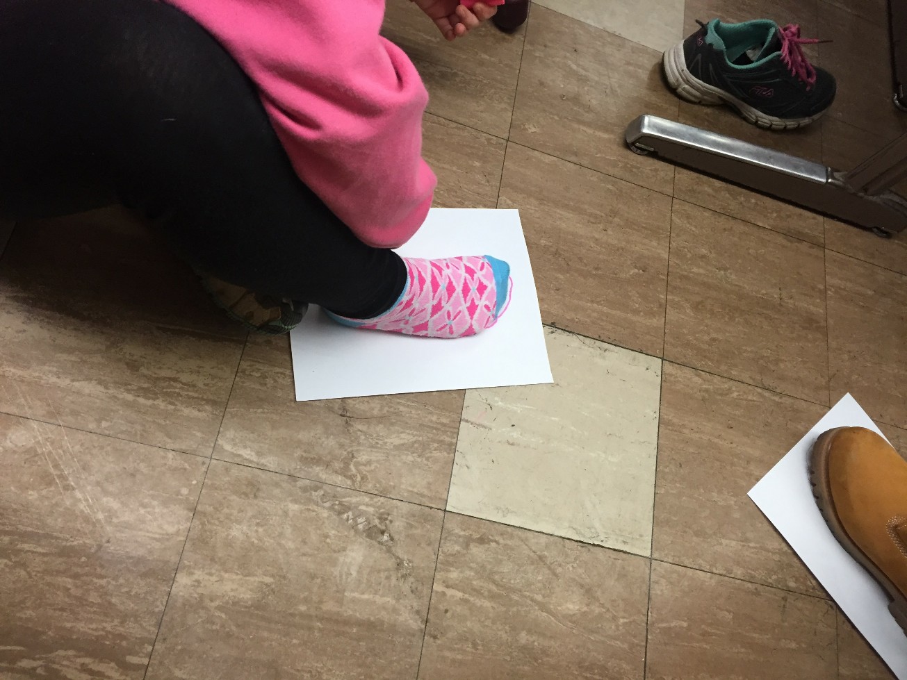 A student puts her foot on a piece of blank paper as part of a lesson on climate change at Cheston Elementary School.