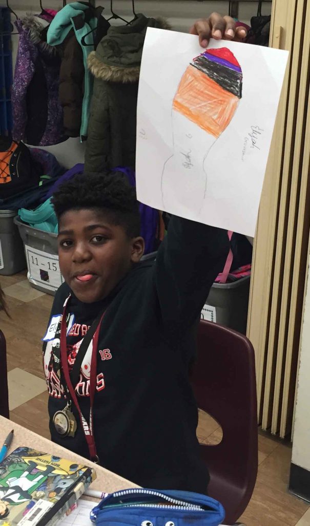 A child holds up his drawing during a class lesson on climate change led by Lafayette College students.