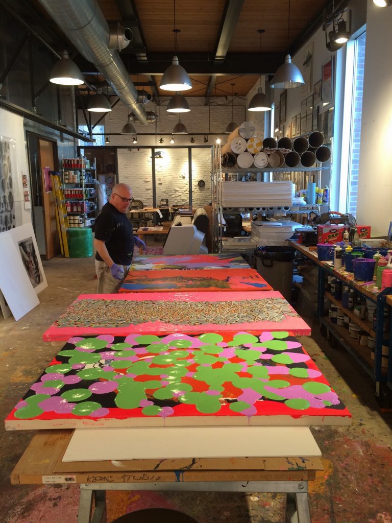 Ed Kerns looks over a few of his octopus-themed paintings.