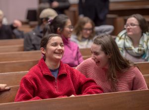 Two students laugh as Laila Lalami, author of this year's Community Reading, Hope and Other Dangerous Pursuits, speaks at Colton Chapel.