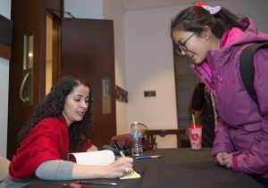 Laila Lalami, author of this year's Community Reading, Hope and Other Dangerous Pursuits, signs a copy of her book for a student after her lecture at Colton Chapel.