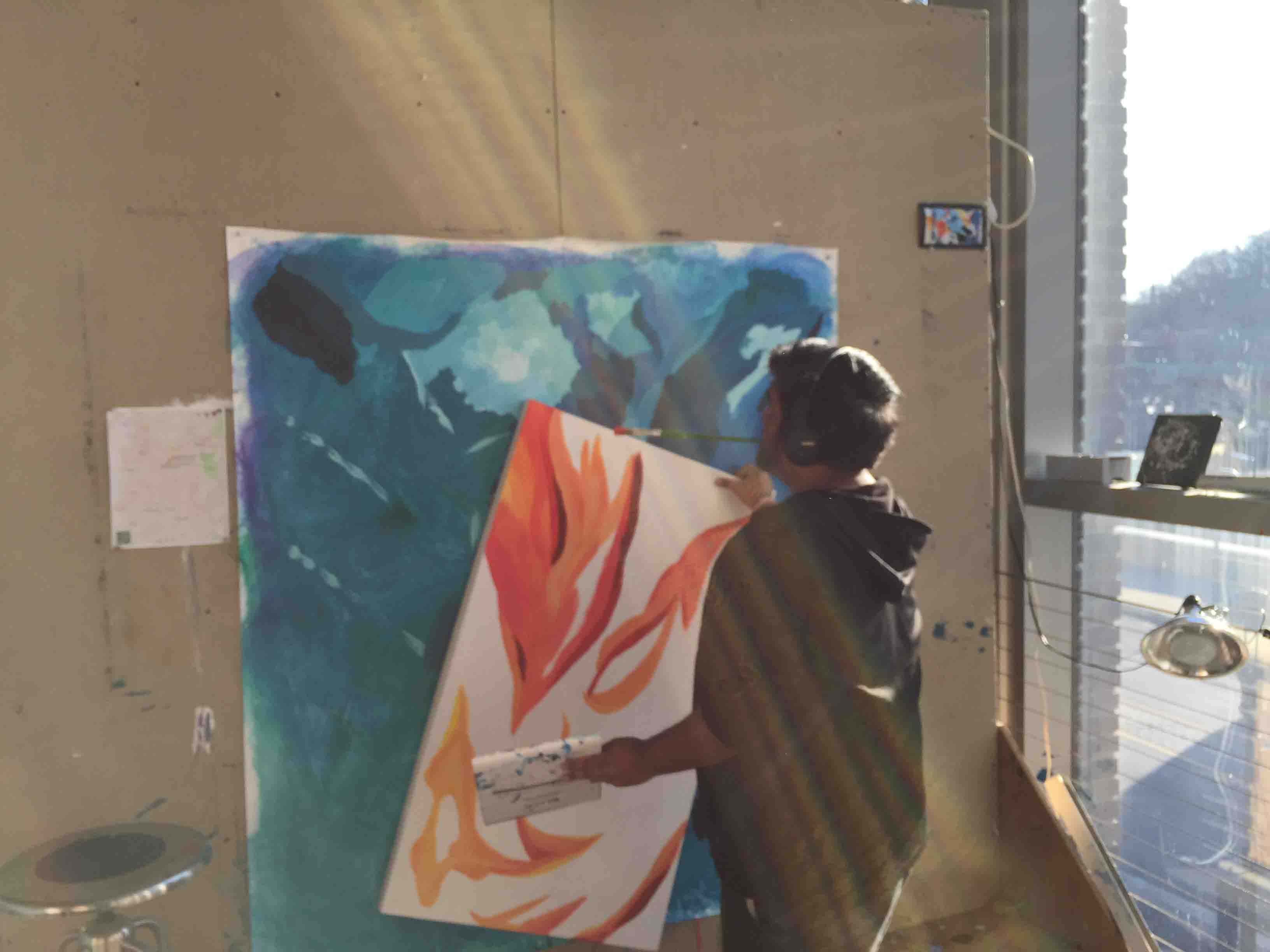 Pablo Pollish '18 moves one of his paintings on canvas in the Williams Visual Arts Building.