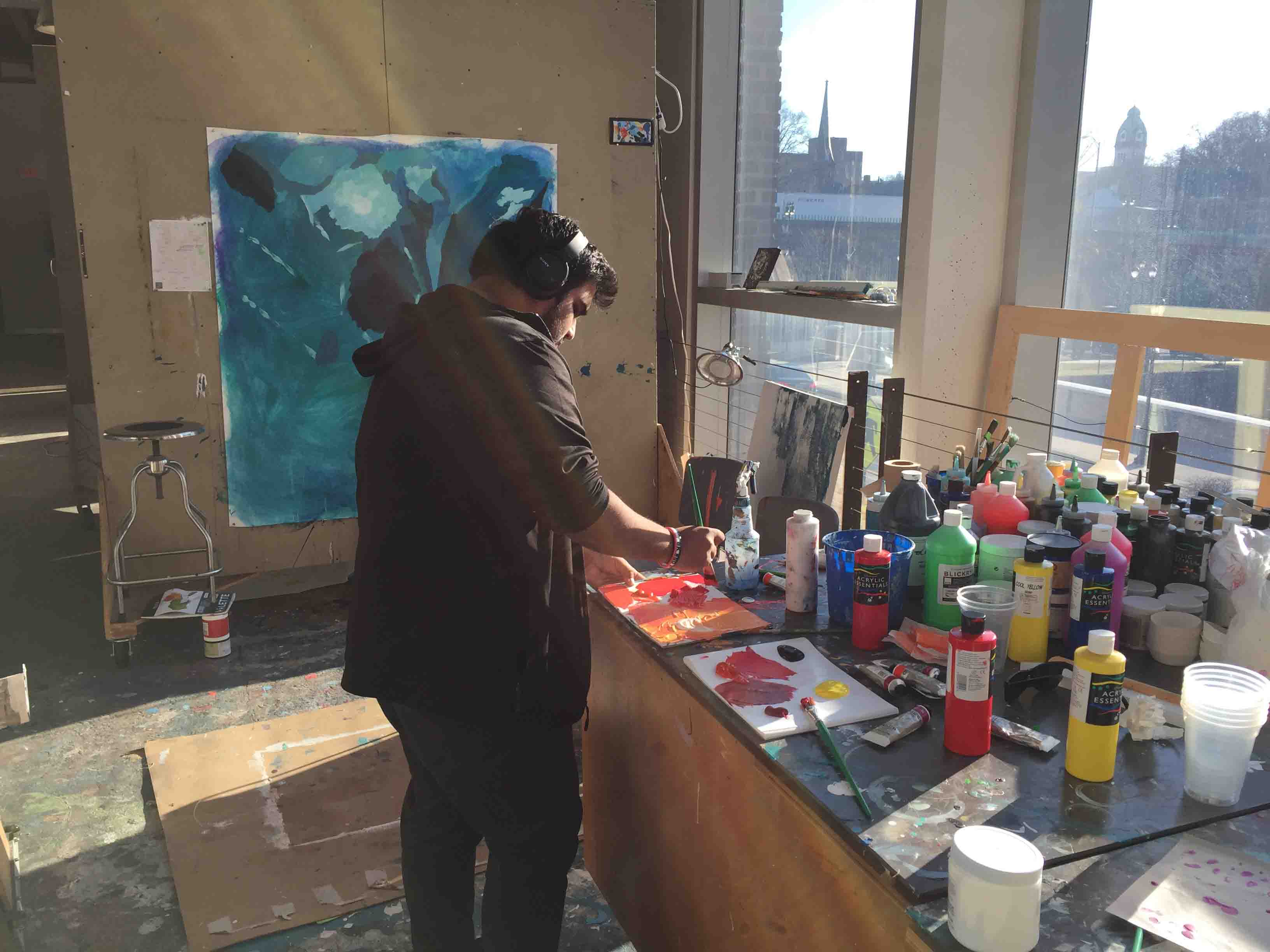 Pablo Pollish '18 paints on canvas in the Williams Visual Arts Building.