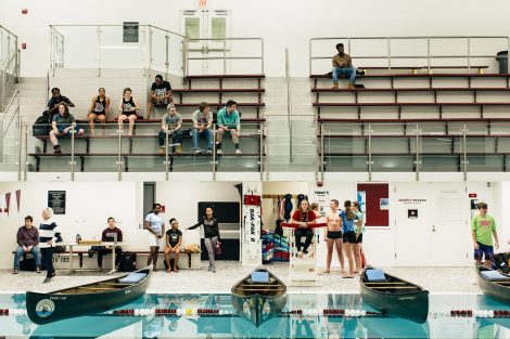 Students try to flood and sink other canoes in the Battleship game in Weinstein Natatorium.