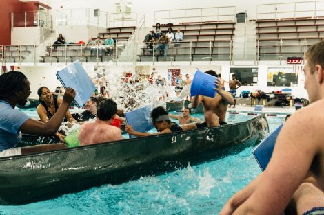 Students try to flood and sink other canoes in the Battleship game in Weinstein Natatorium.