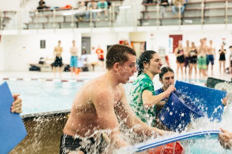 Students try to flood and sink other canoes in the Battleship game in Weinstein Natatorium.