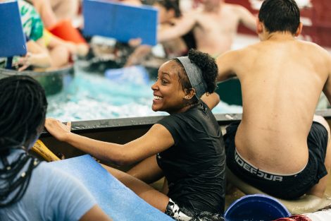 Students try to flood and sink other canoes in the Battleship game in Weinstein Natatorium.