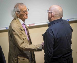 World-famous environmental artist Christo shakes the hands of Professor Ed Kerns after giving the 2018 Grossman Visiting Artist lecture.