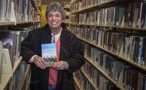 Pioneering feminist, activist, and author Rita Mae Brown holds a copy of her book Cakewalk.