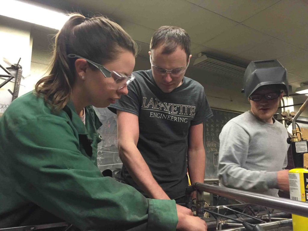 Students work on their steel bridge model.