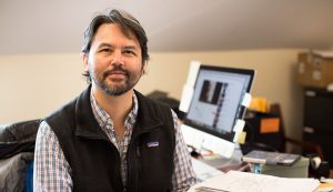 Christopher Lee smiles in his office