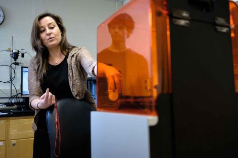 A professor grabs a product from the 3D printer.