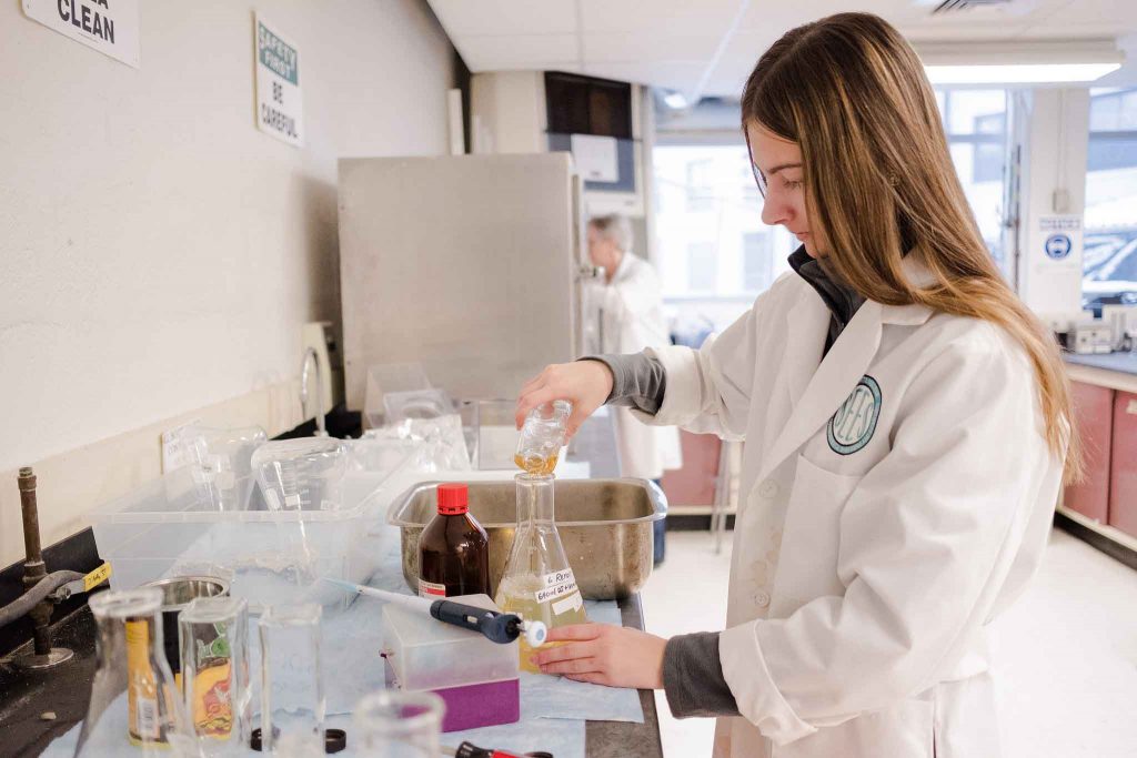 A student works in the lab on the biofilm project.