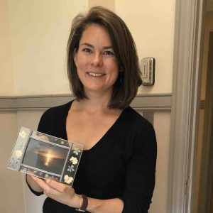 Annie De Saussure holds a photo of Voyageurs National Park.