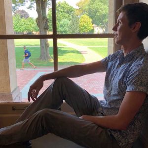 Mathieu Perrot sits on a window sill.